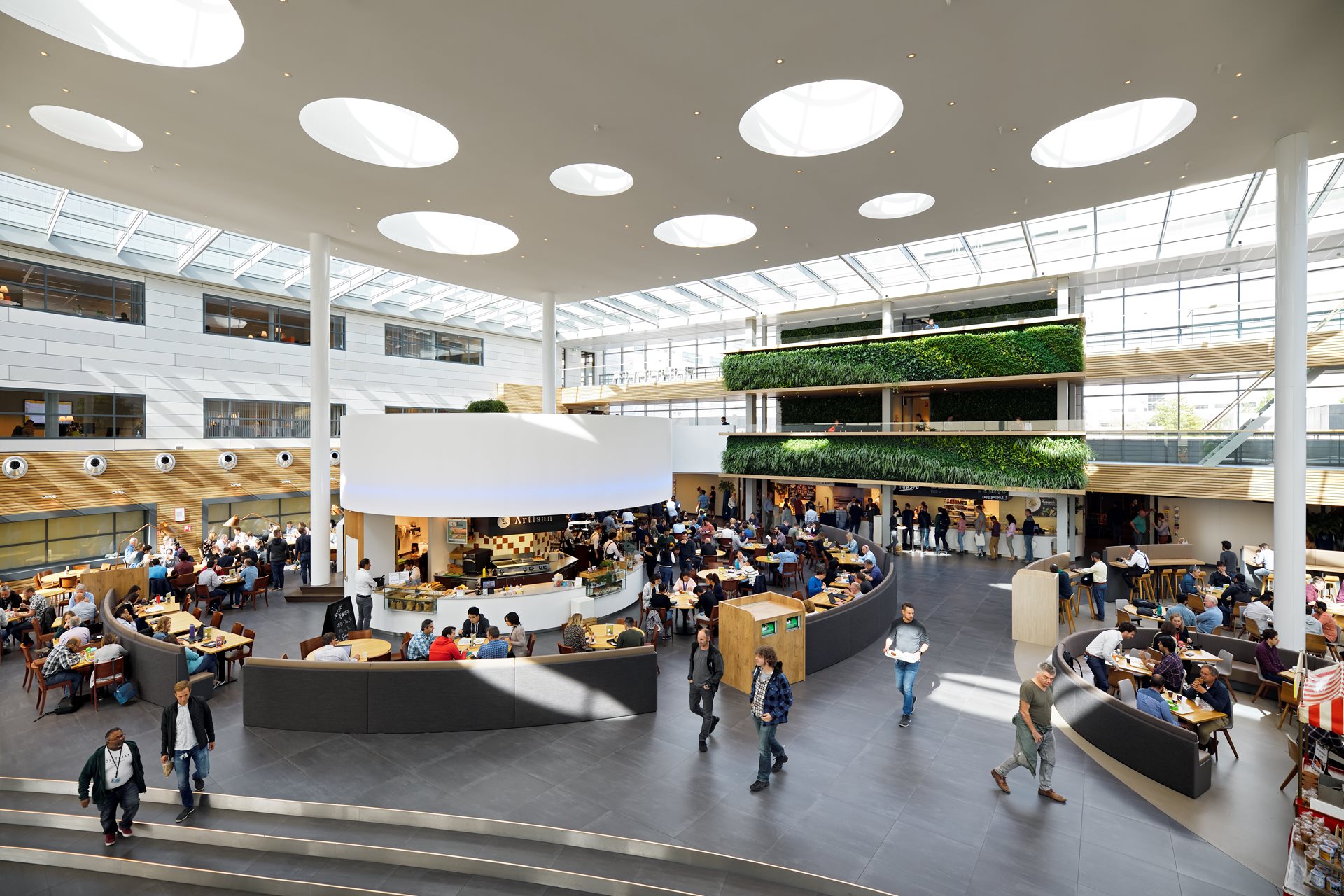 An overhead view of the cafeteria in the ASML headquarters, with people walking and sitting across the room. 