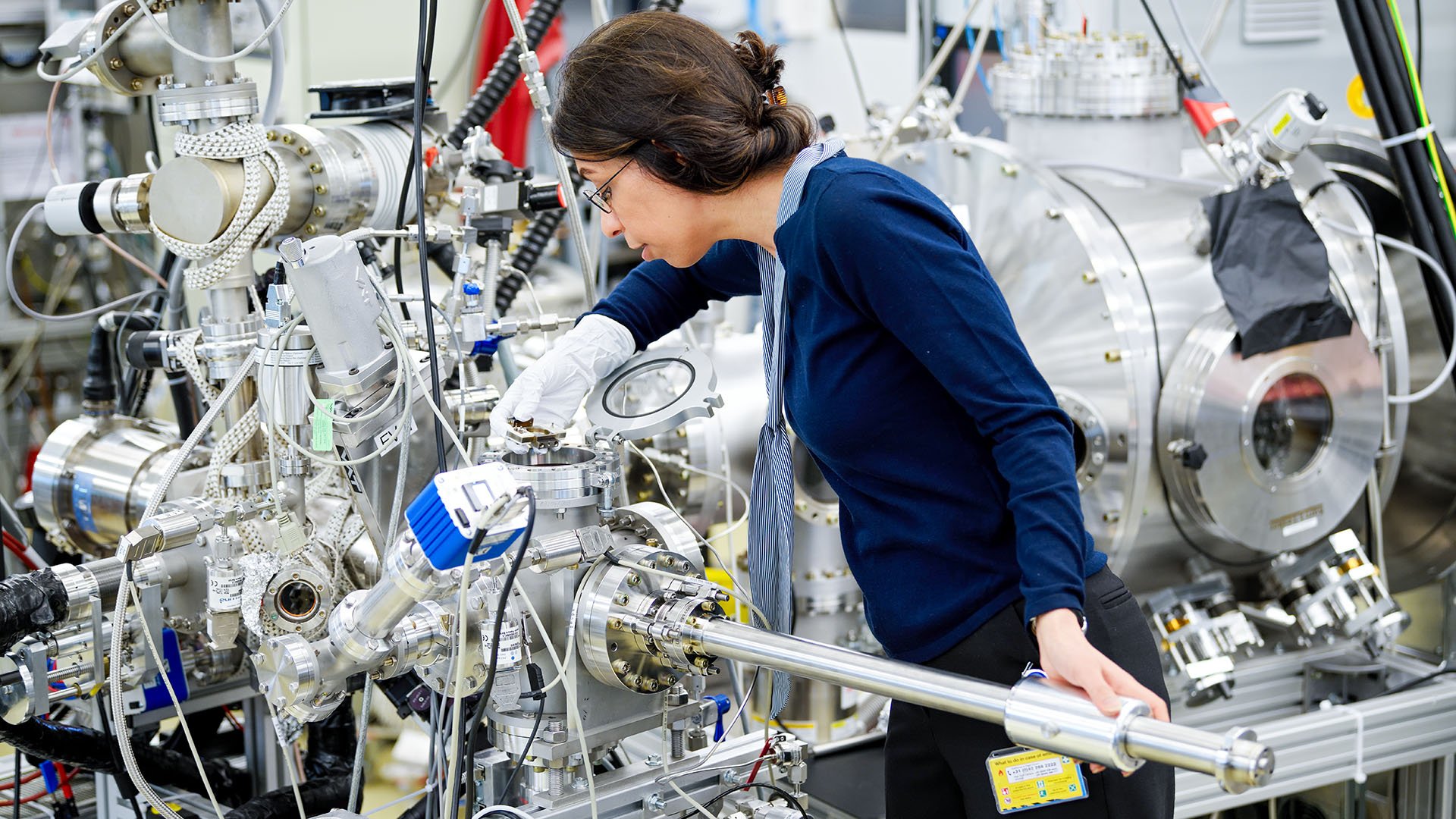 An ASML technician carefully adjusts complex equipment.