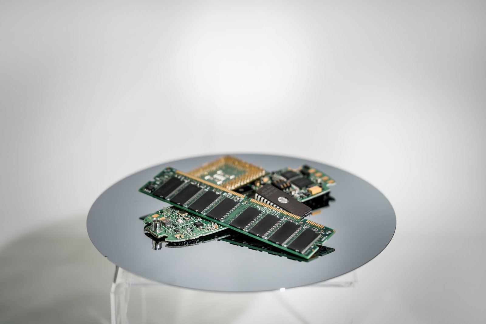 Various old microchips, some within circuit boards, piled on a silicon wafer. Various old microchips, some within circuit boards, piled on a silicon wafer.