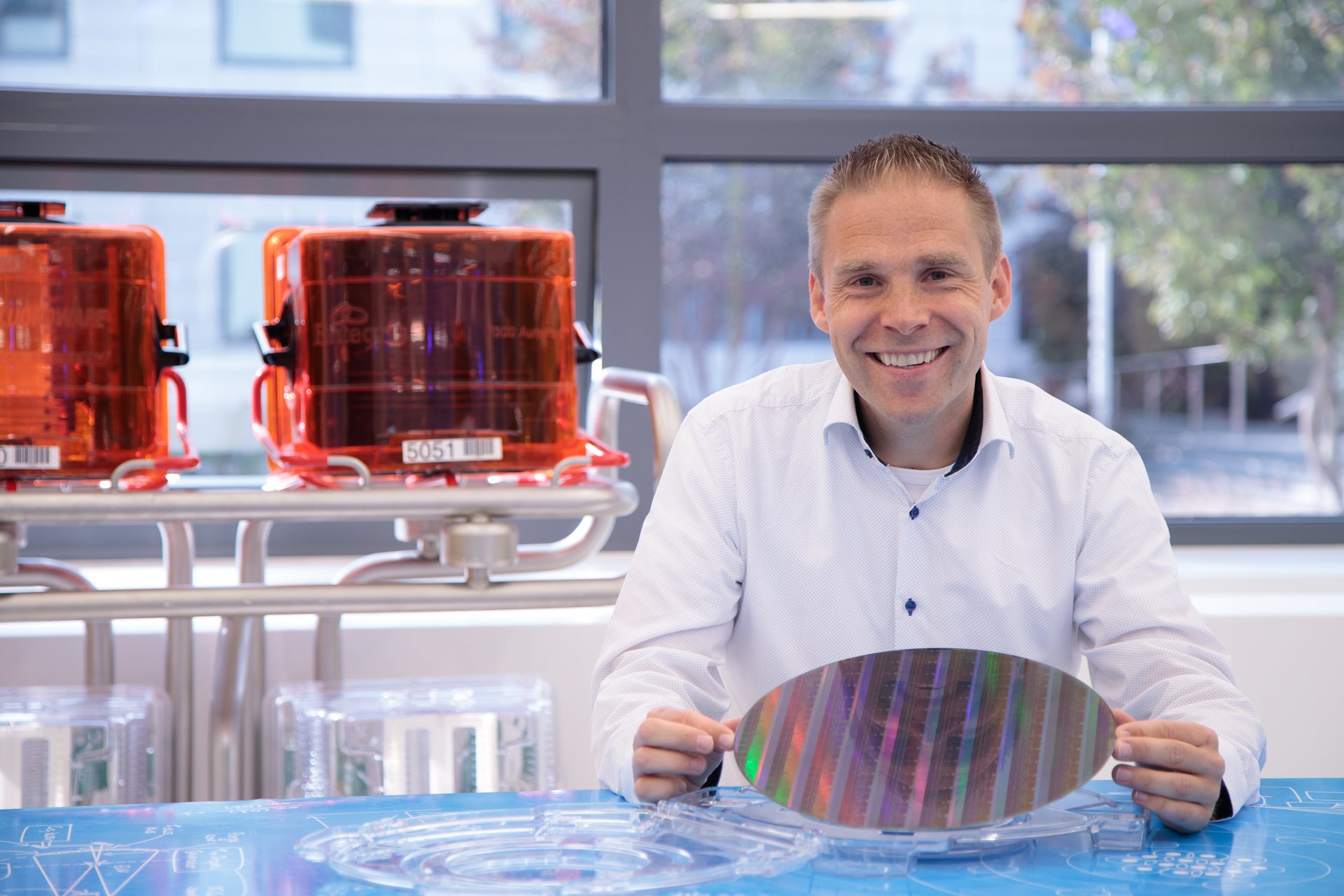 ASML Fellow Simon Mathijssen holds a multi-colored microchip wafer. ASML Fellow Simon Mathijssen holds a multi-colored microchip wafer.