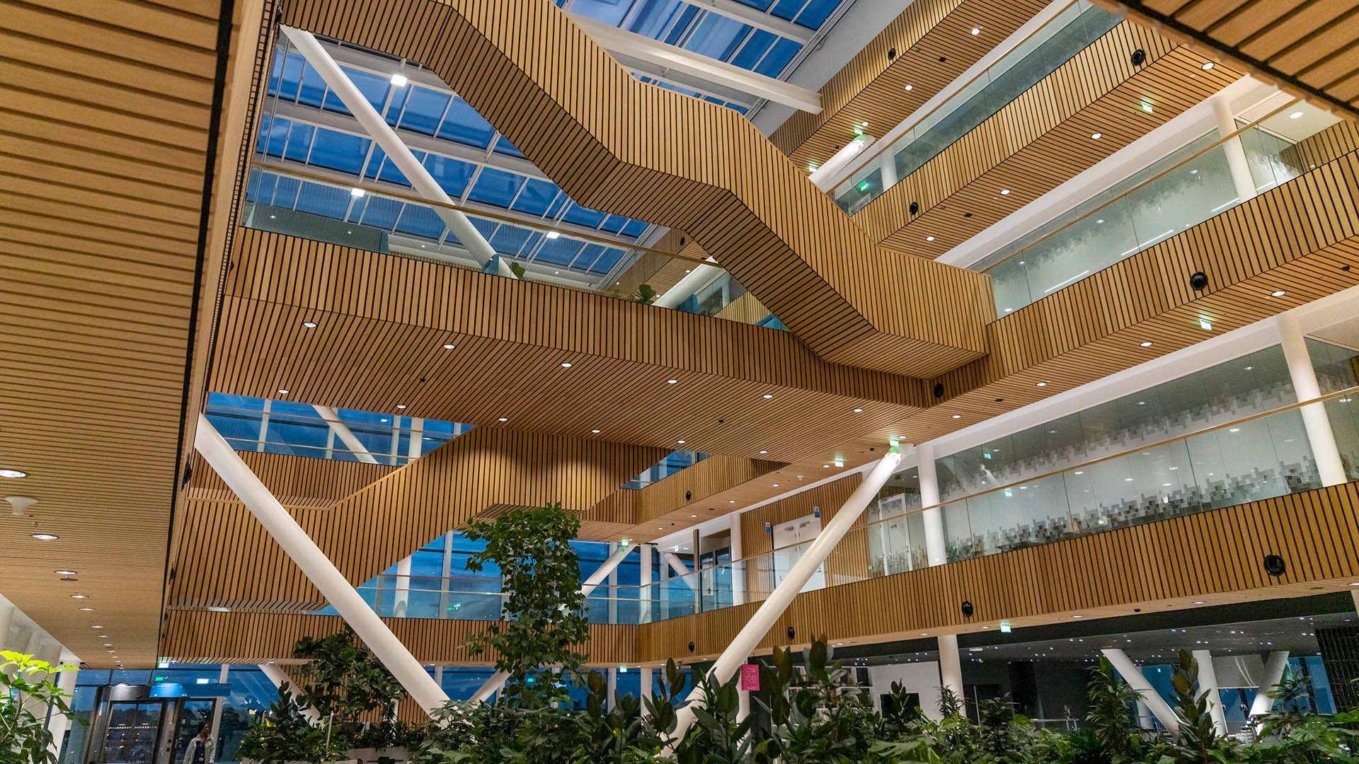 Open building interior with multiple levels and staircases under skylights Open building interior with multiple levels and staircases under skylights