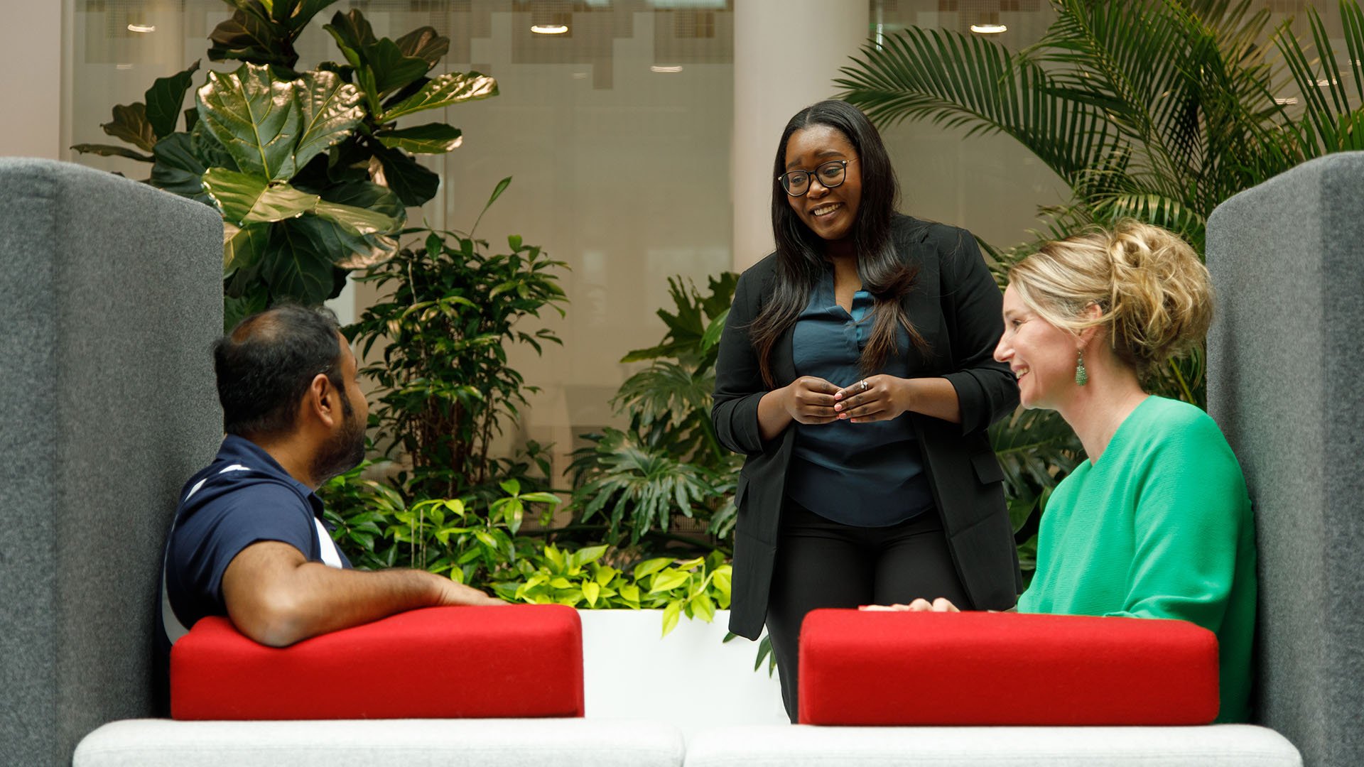 Person standing speaking to two people seated in a booth Person standing speaking to two people seated in a booth