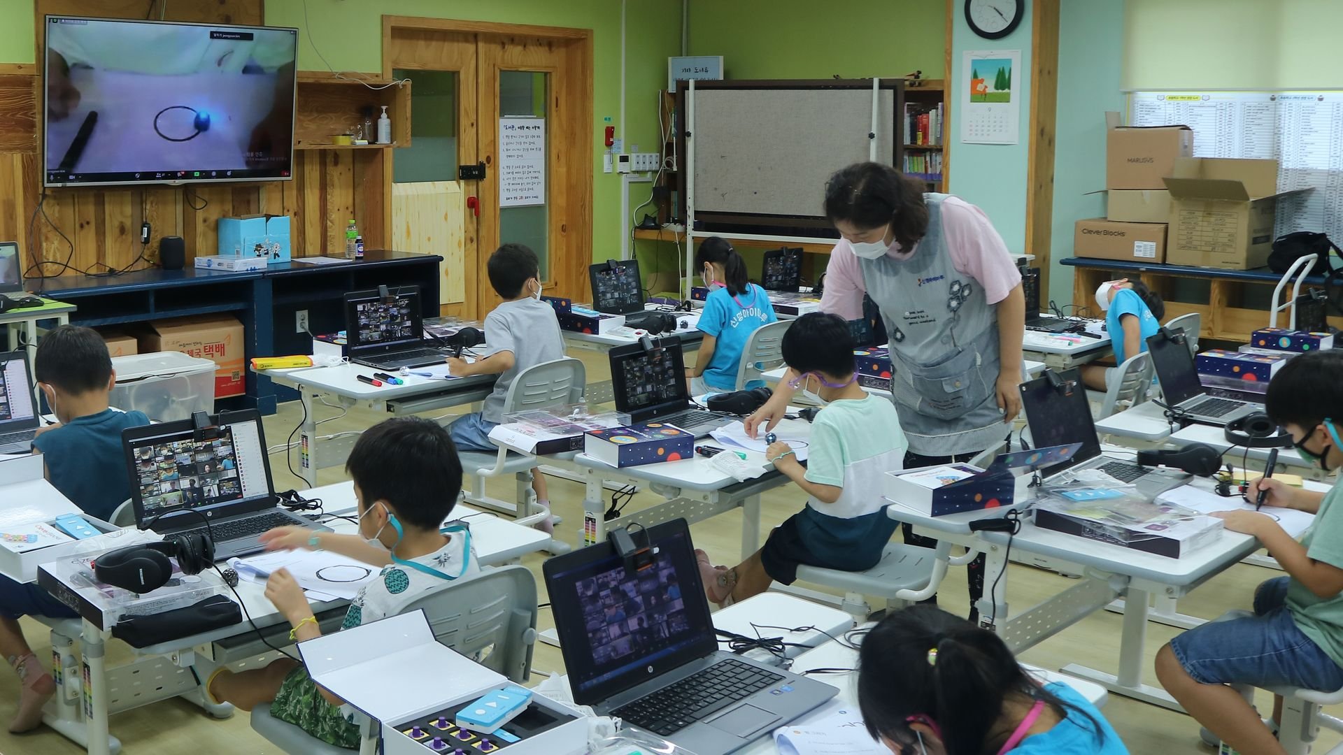 children sitting at desks in classroom with teacher children sitting at desks in classroom with teacher