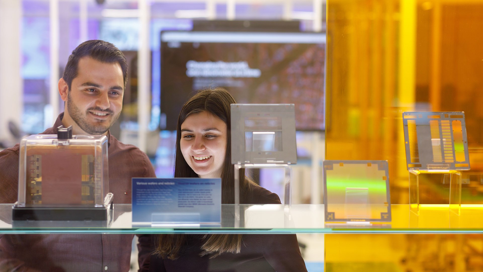 Two people looking at a display of silicon wafers Two people looking at a display of silicon wafers